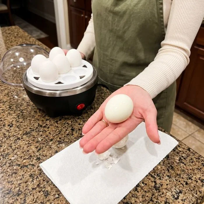 A freshly peeled egg next to the cooker